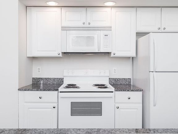 White kitchen cabinets and appliances at Victory Building Apartments