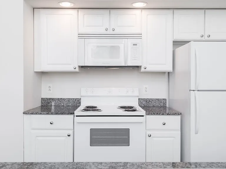 White kitchen cabinets and appliances at Victory Building Apartments