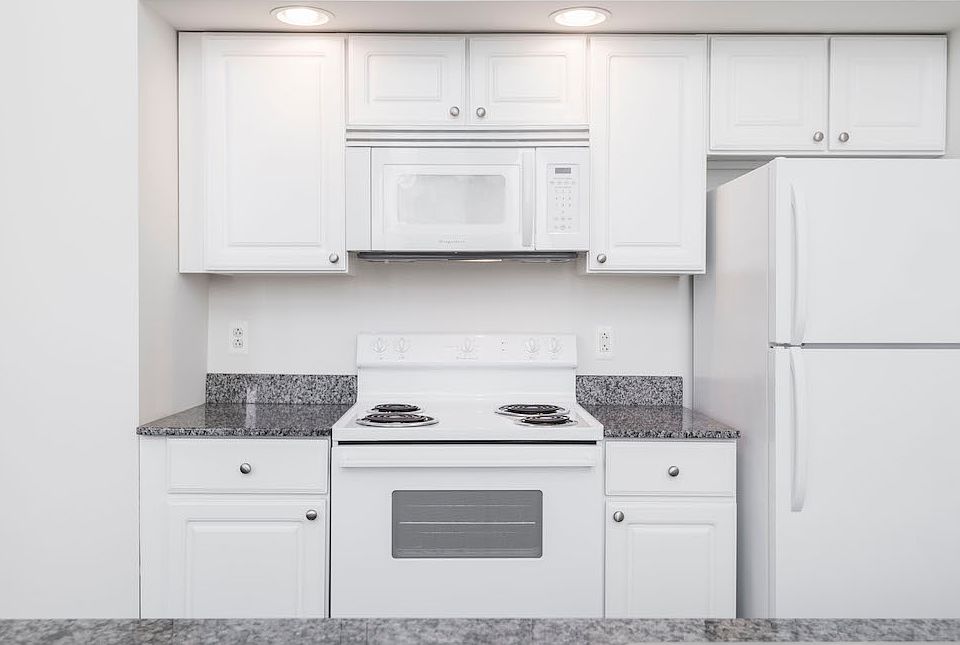 White kitchen cabinets and appliances at Victory Building Apartments