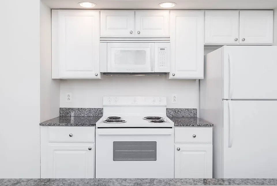 White kitchen cabinets and appliances at Victory Building Apartments