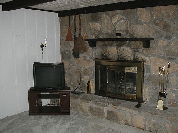 den fireplace w beamed ceiling