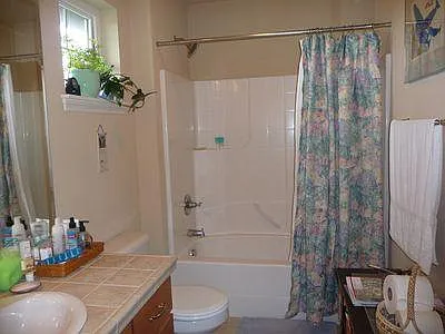 Upstairs bathroom has a shower/ tub, single sink vanity, countertop and floor are ceramic tile.