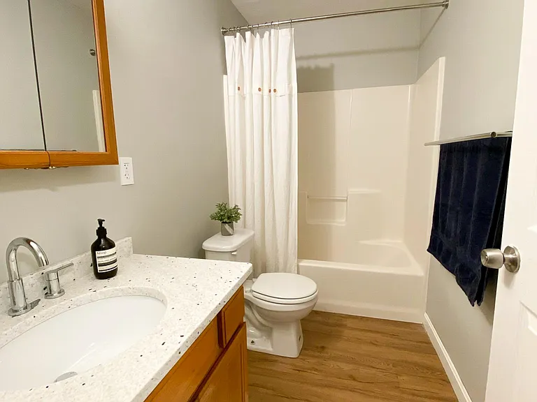 This full bathroom has brand new custom granite countertops and chrome accessories.
