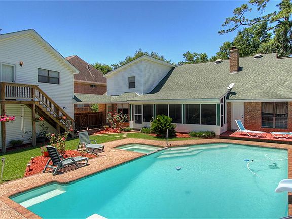View of the back of the home showing the pool and garage apartment.