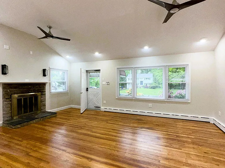 livingroom with fireplace. cathedral ceiling. livingroom opens to dining room ,kitchen and hallway to bedrooms