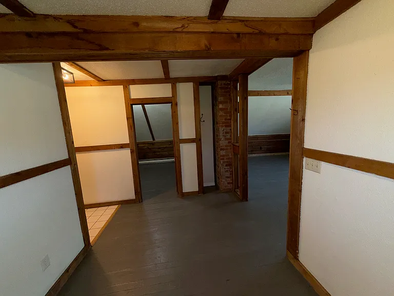 dining room area kitchen left, bedroom door center, living room right