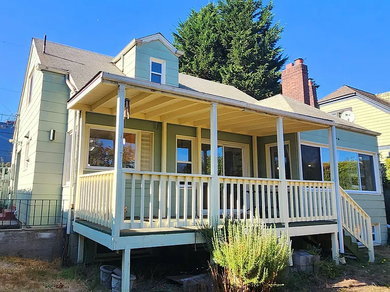 Rear facing photo with deck and stairs to garden