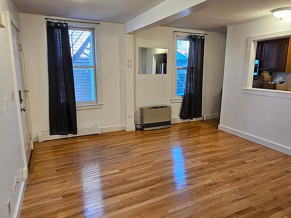 Main living area, lovely hardwood floors and high ceilings. Large windows that let in light, help keep out noise. A helpful separation wall between living area and kitchen.