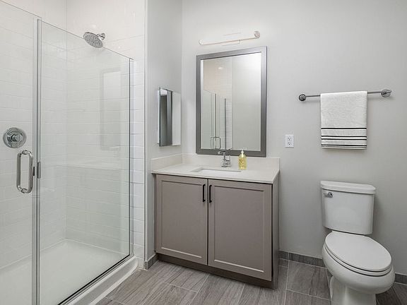 Coming Soon - New West Phase apartments - Finish Package IV Bathroom with white quartz countertops, gray cabinetry, and hard surface flooring (Representative photo)