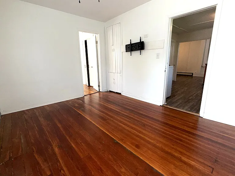 Living room off kitchen with built in storage and tv mount, spacious for a couch and loveseat