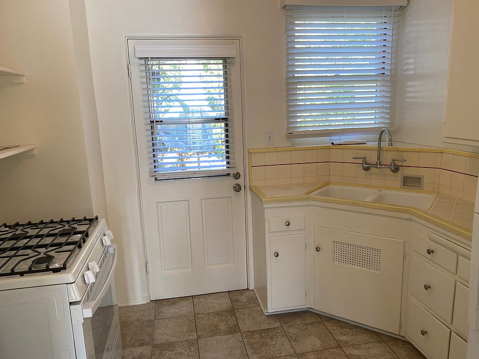 Tile floor kitchen_new stove and refrigerator_door is rear entrance 
onto shared deck.