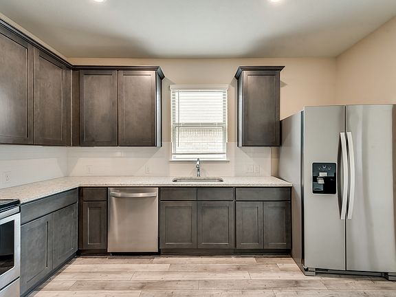 Enjoy stunning granite countertops and designer wood cabinetry in the kitchen.