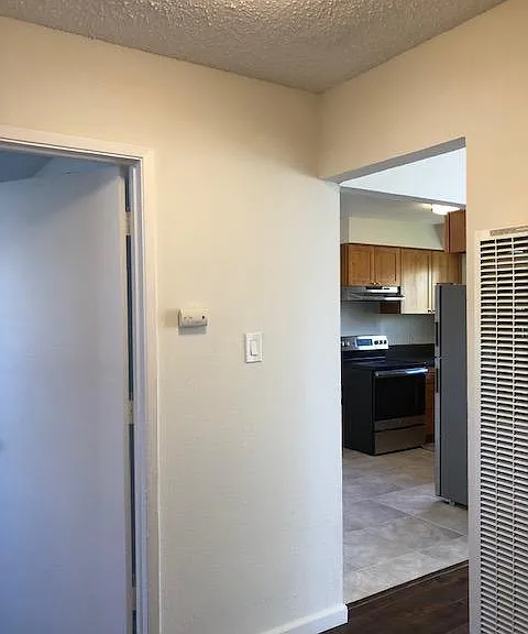Hall from the living space to the bathroom and both bedrooms has wood laminate flooring, double sided wall heater