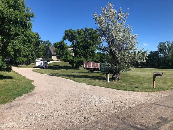 Street view of circle driveway leading to garage parking pad and front walkway to front porch. Front yard, backyard, and part of extra lot achrage.