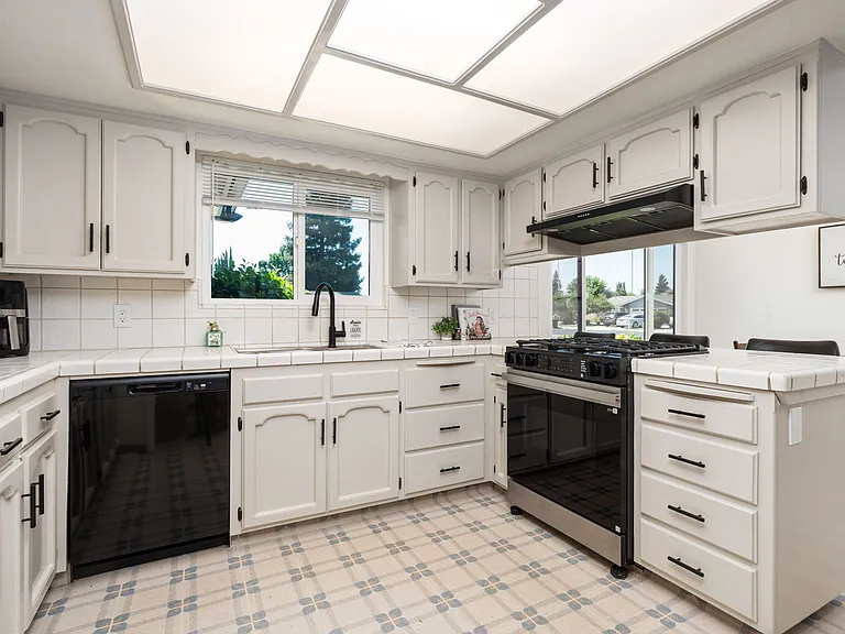 Fully stocked kitchen with fridge, stove and ovens.
