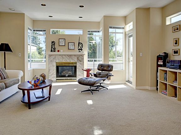 Spacious living room. Imagine relaxing in front of the fireplace or just reading and listening to the music. Surround sound throughout the entire house. The door to one of the decks to the right. And did you notice high ceilings?