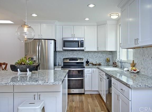 Granite counters, white cabinets & stainless appliances highlight this kitchen.