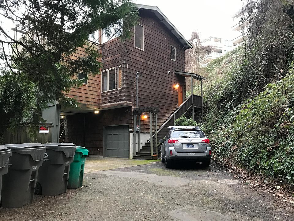 Driveway at end of cut de sac on SW 21st Ave. Hillside on right. Market street above hillside.