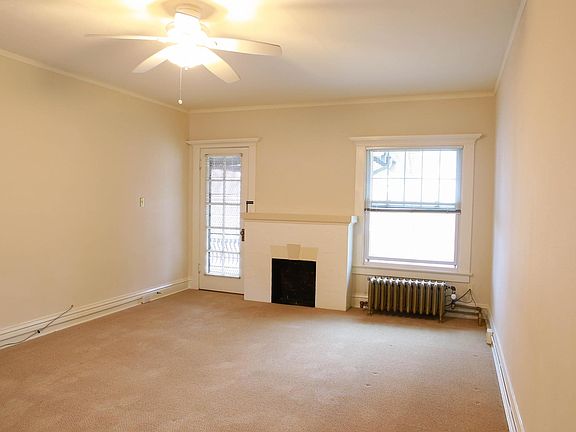 Apt. D, west-facing living room, door to balcony, non-working fireplace