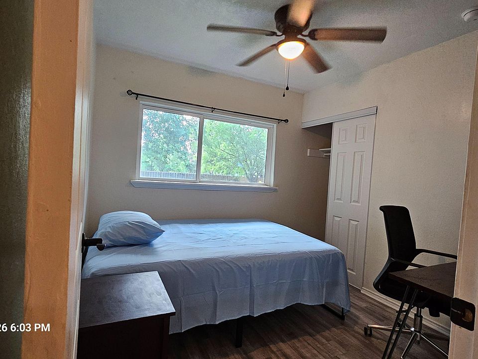 Private bedroom with a ceiling fan, large window, and closet storageideal for a simple, functional setup.