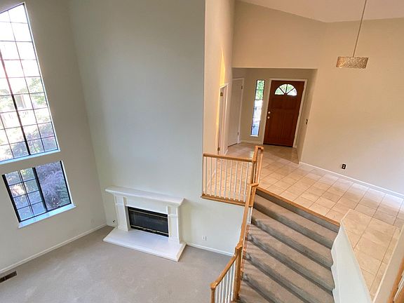 Foyer overlooks living/family room with gas fireplace and vaulted ceiling