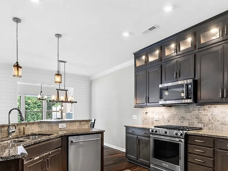 Well appointed kitchen with custom cabinets to the ceiling with high-end appliances
