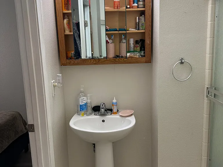 Master bedroom sink and medicine cabinet with mirror doors open.