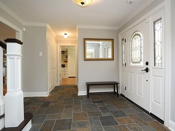 The entryway is light and bright with an oversized custom front door with decorative glass.