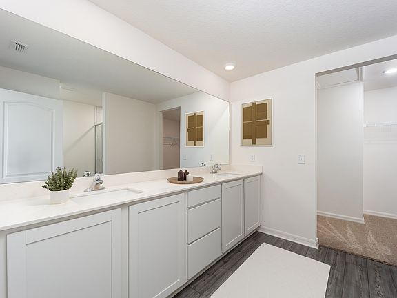 The master bathroom includes a stunning dual sink vanity and walk-in closet