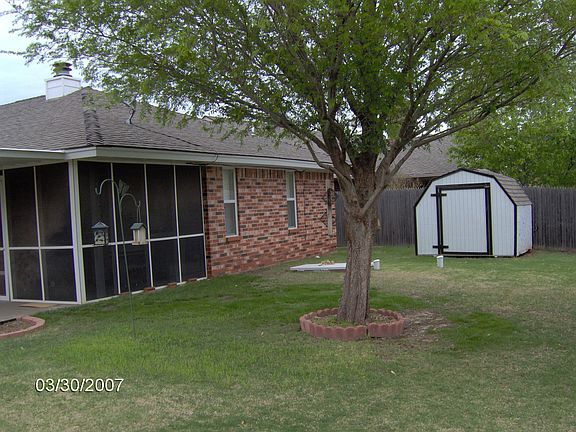Great backyard with view of screened porch, storage building & storm shelter!