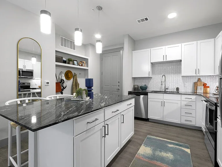 Stunning kitchens feature quartz countertops and herringbone tile backsplash.