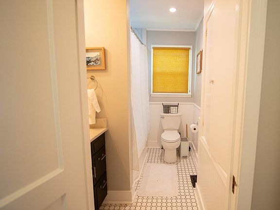Downstairs bathroom is located between two bedrooms. It has a bathtub/shower, vanity sink and toilet. It is near the living room for guest use.