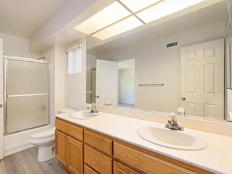 Spacious jack & jill bath with dual sinks and tub / shower.