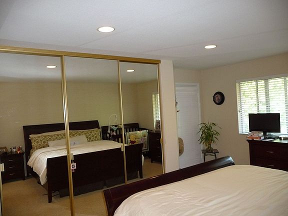 Master bedoom with mirrored closet and recessed lighting