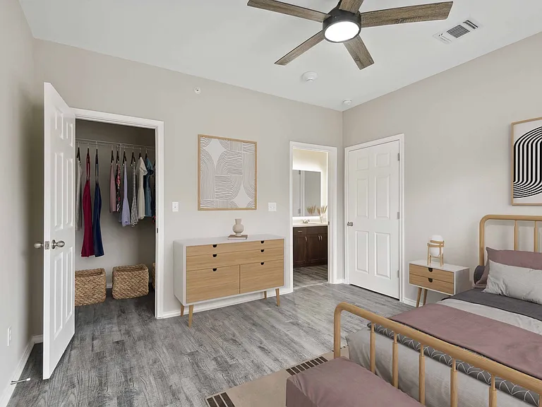 Bedroom with large closet, wood-style plank flooring, and ceiling fan.