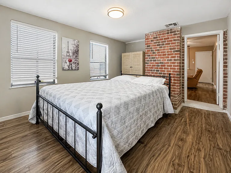 Charming bedroom with an exposed brick wall. A unique space to relax during your stay.