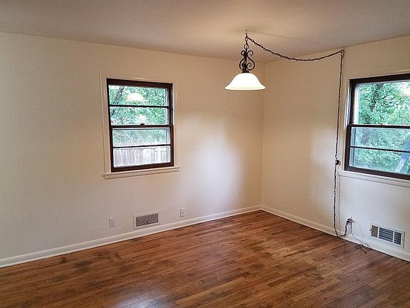 Another view of living room with windows and hanging lamp...