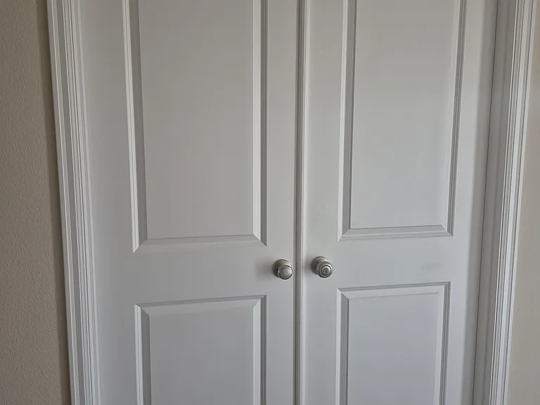 Double doors to office space which includes a storage closet.