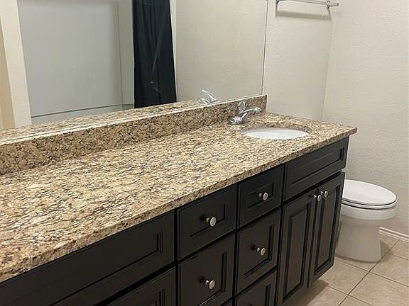 Bathroom with tile patterned flooring, vanity, and toilet