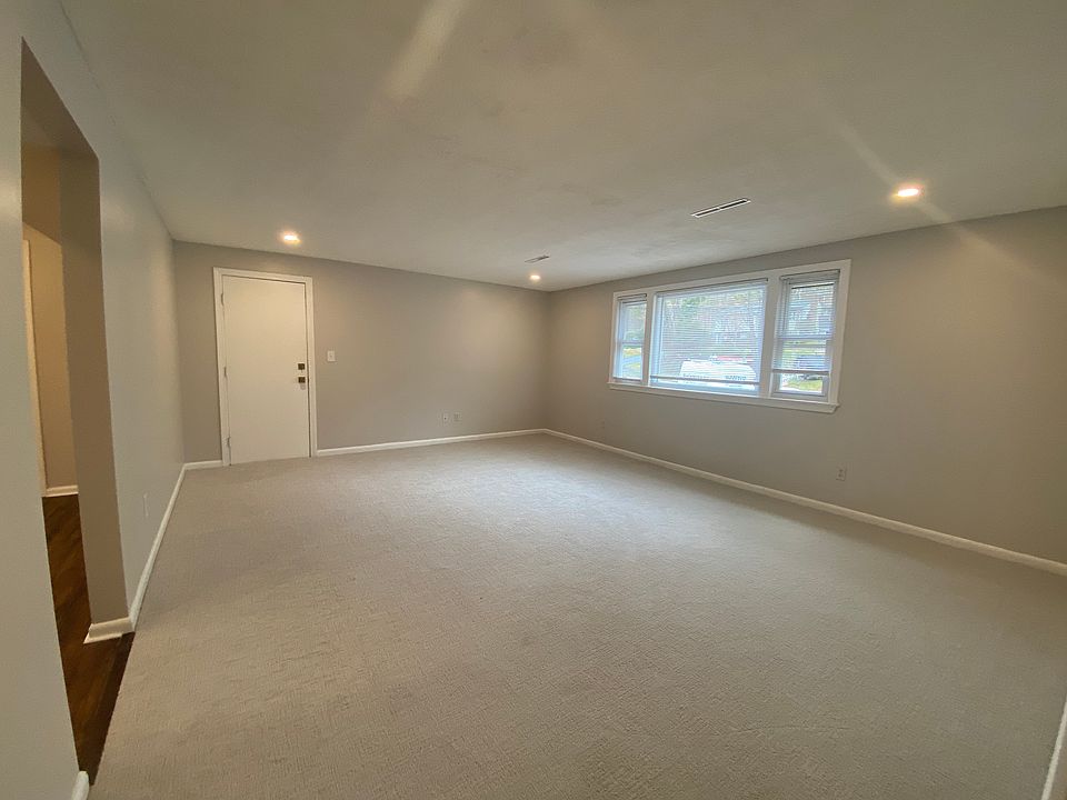 Large living room with picture window facing the front. Recessed lights and new plush textured carpeting.