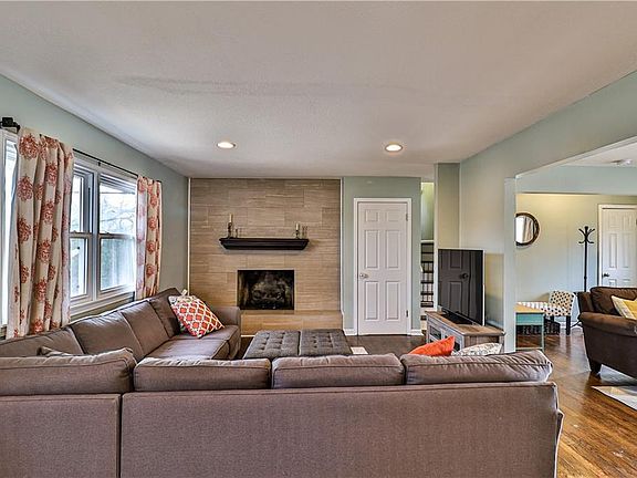 Large family room with modern custom tiled fireplace, hardwood floor and deck access!