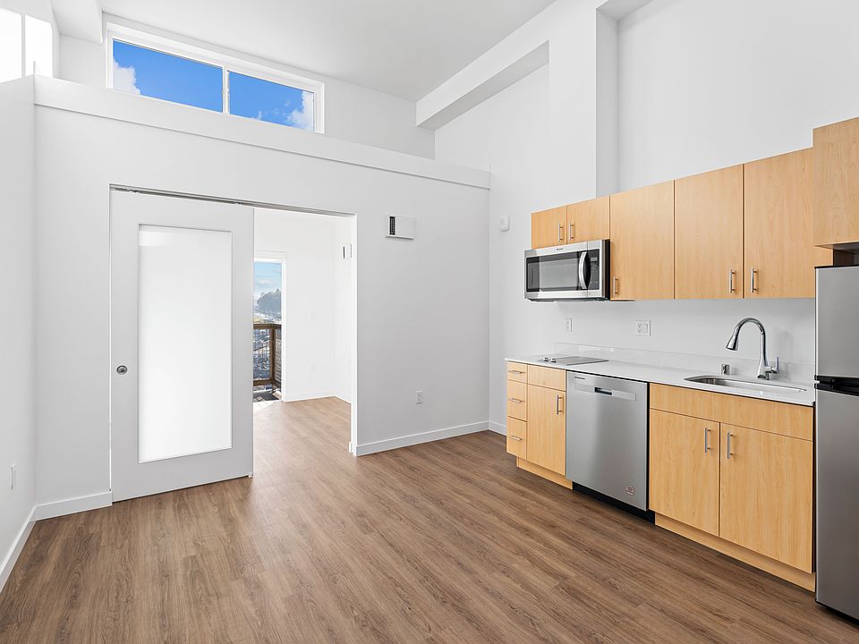 Enjoy cooking in this modern kitchen featuring sleek wood flooring, ample cabinet space, and a clean, open design.