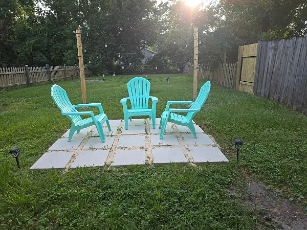 Large fenced in backyard with a peaceful sitting area