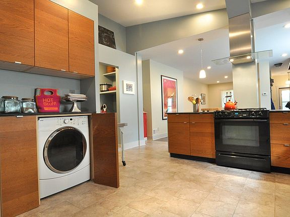 Hidden front-loading washer and dryer inside kitchen cabinets.