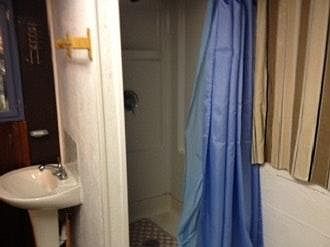 ALONG SIDE SHOWER, COVERED BY CURTAINS IS A BIG STORAGE AREA.