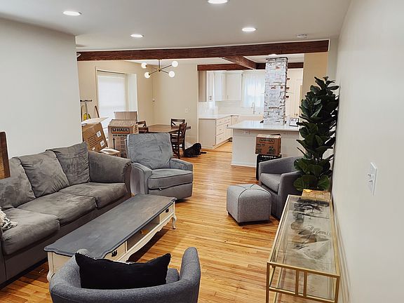 Open den area with decorative chimney and beams