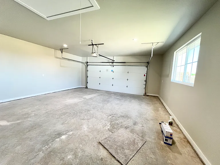 Oversized, two car garage with garage door opener, keyless entry, and additional attic storage