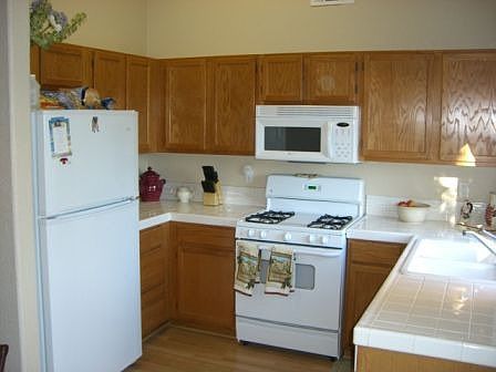 Kitchen with All White Appliances and Tile Countertops 