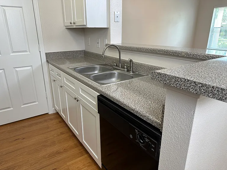 Modern kitchen with sleek countertops, elegant white cabinets, and a double sink, ideal for culinary creativity. Modern kitchen with sleek countertops, elegant white cabinets, and a double sink, ideal for culinary creativity.