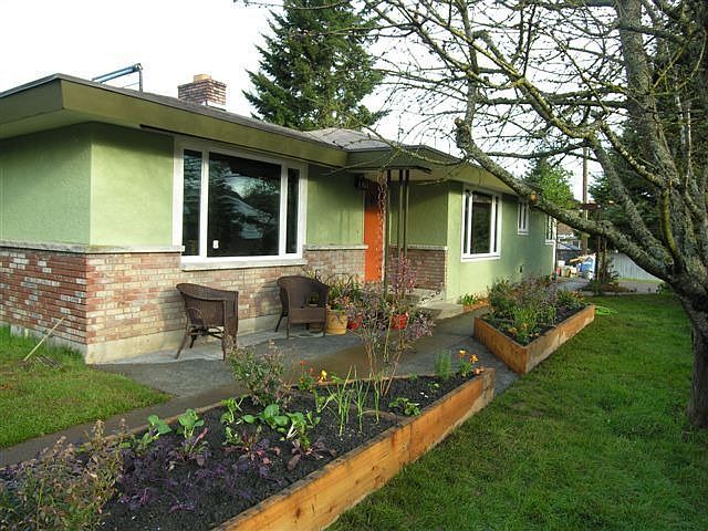 Front of the home. Pervious concrete patio, rainwater catchment system waters the raised beds that a